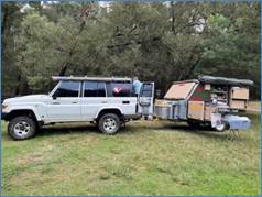 A car with a trailer on grass

Description automatically generated